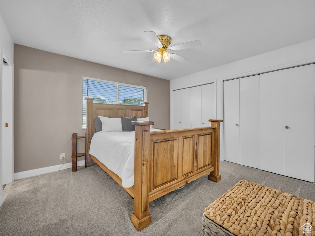 Bedroom featuring multiple closets, baseboards, a ceiling fan, and carpet floors