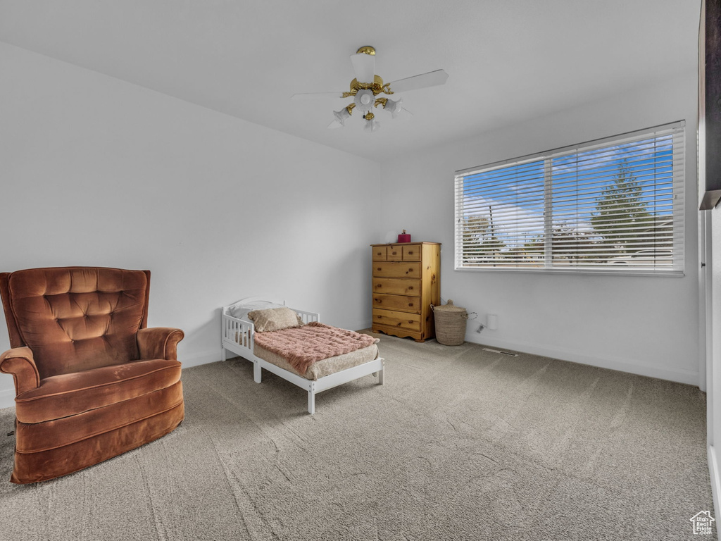 Sitting room with carpet floors, a ceiling fan, and baseboards