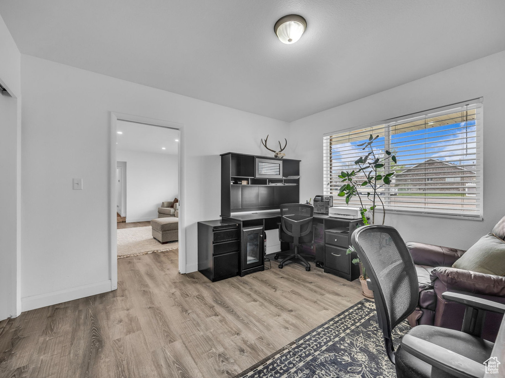 Office area featuring baseboards and light wood-style flooring