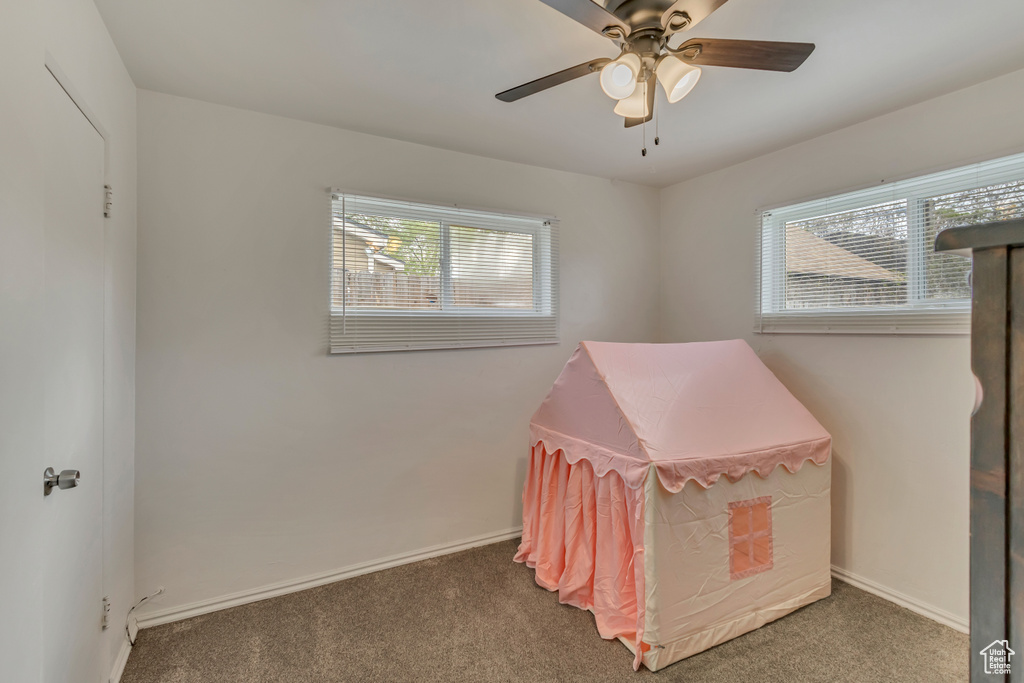 Carpeted bedroom featuring baseboards and a ceiling fan