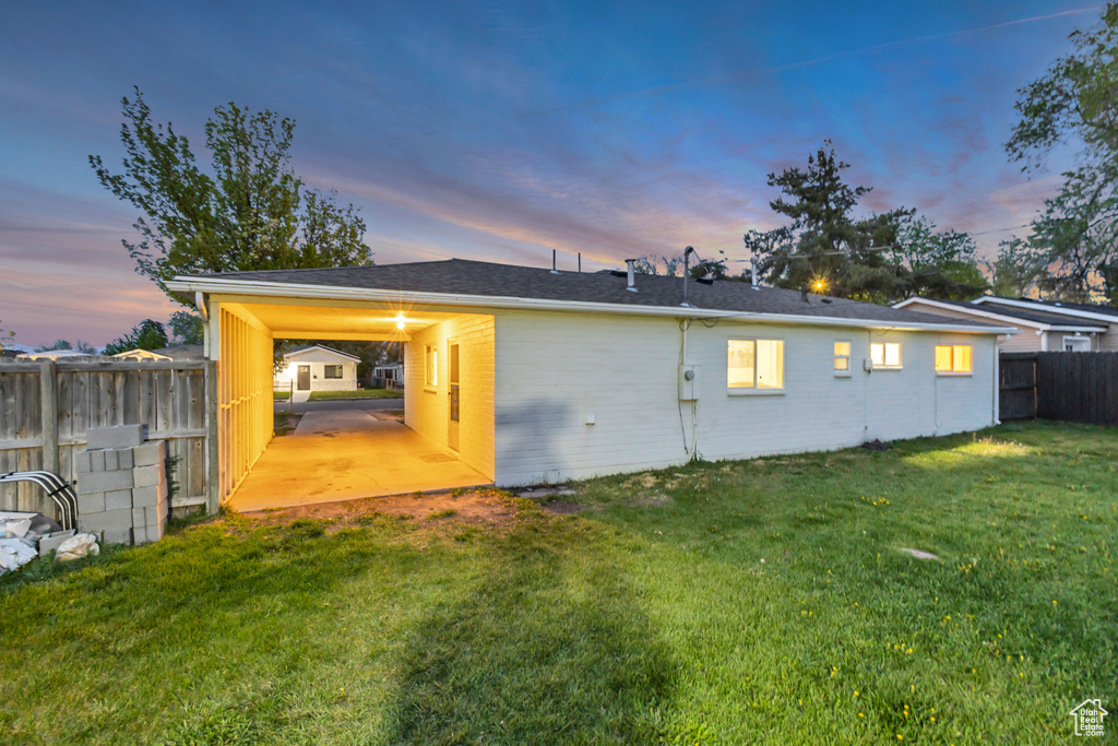 Rear view of house with a lawn, a fenced backyard, and brick siding