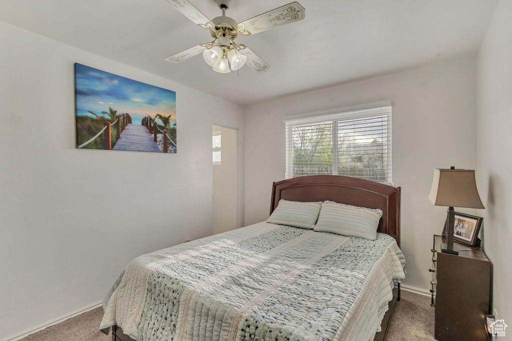 Carpeted bedroom with a ceiling fan and baseboards