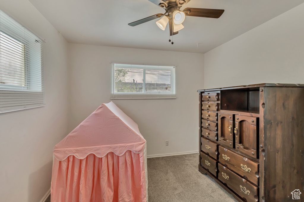 Carpeted bedroom with baseboards and a ceiling fan