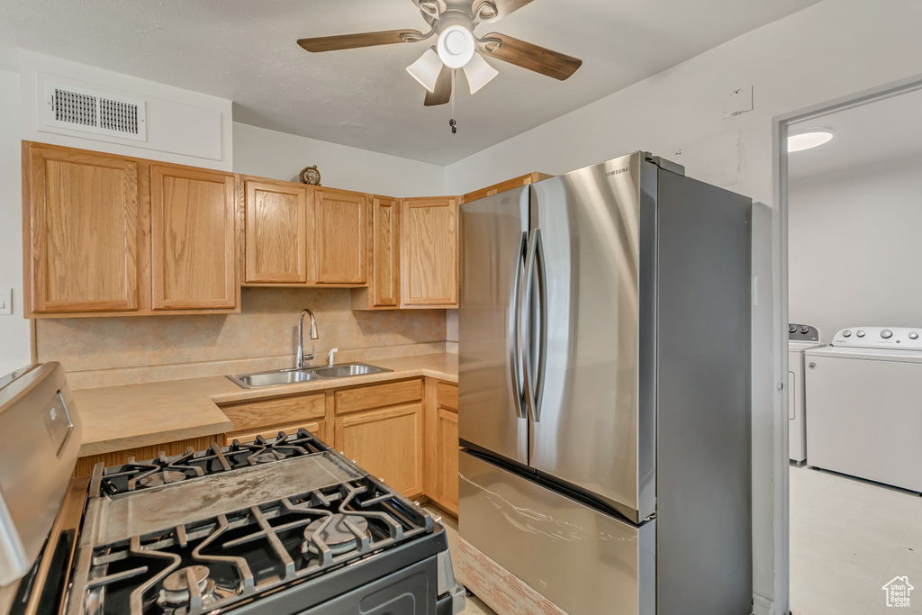 Kitchen featuring a sink, separate washer and dryer, light brown cabinets, and freestanding refrigerator