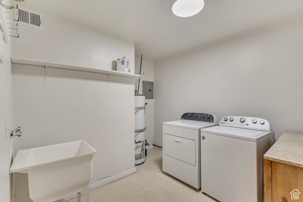 Laundry area featuring a sink, visible vents, water heater, washer and dryer, and laundry area