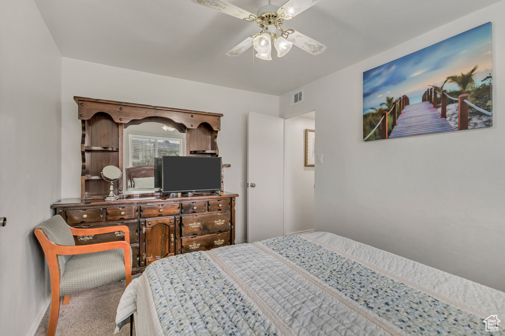 Carpeted bedroom featuring visible vents and a ceiling fan
