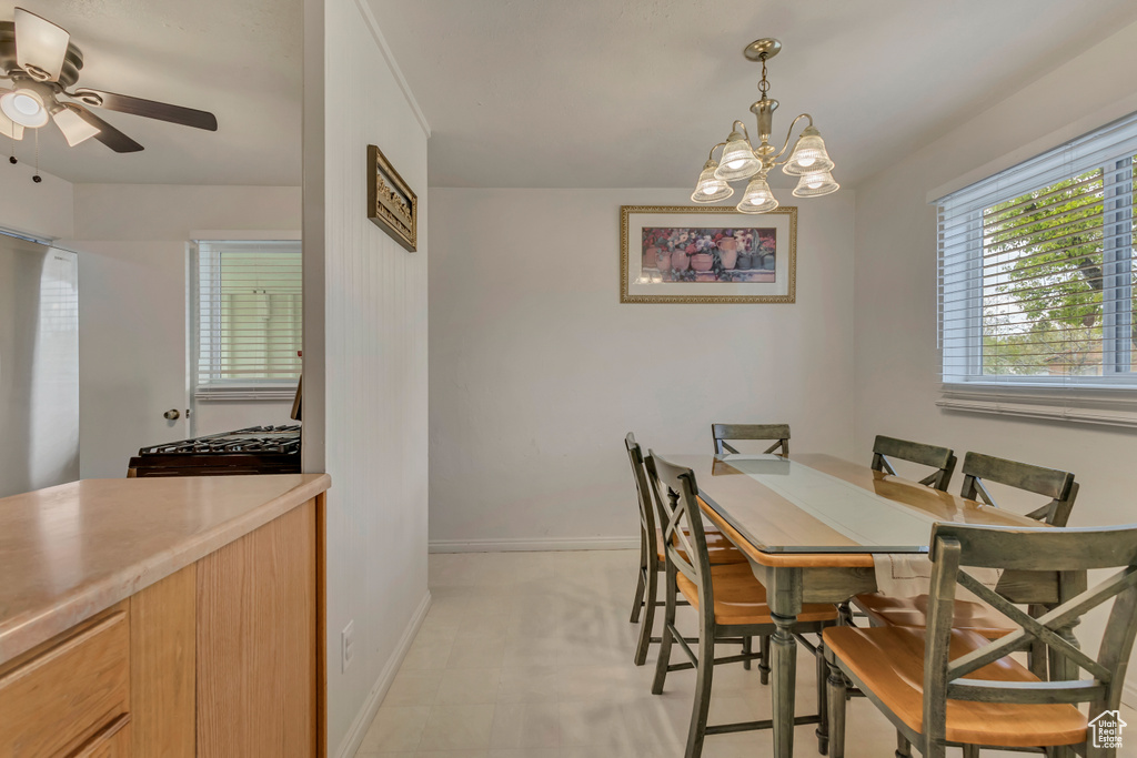 Dining room featuring baseboards and ceiling fan with notable chandelier