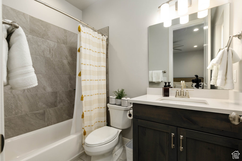 Full bathroom featuring vanity, toilet, and shower / bathtub combination with curtain