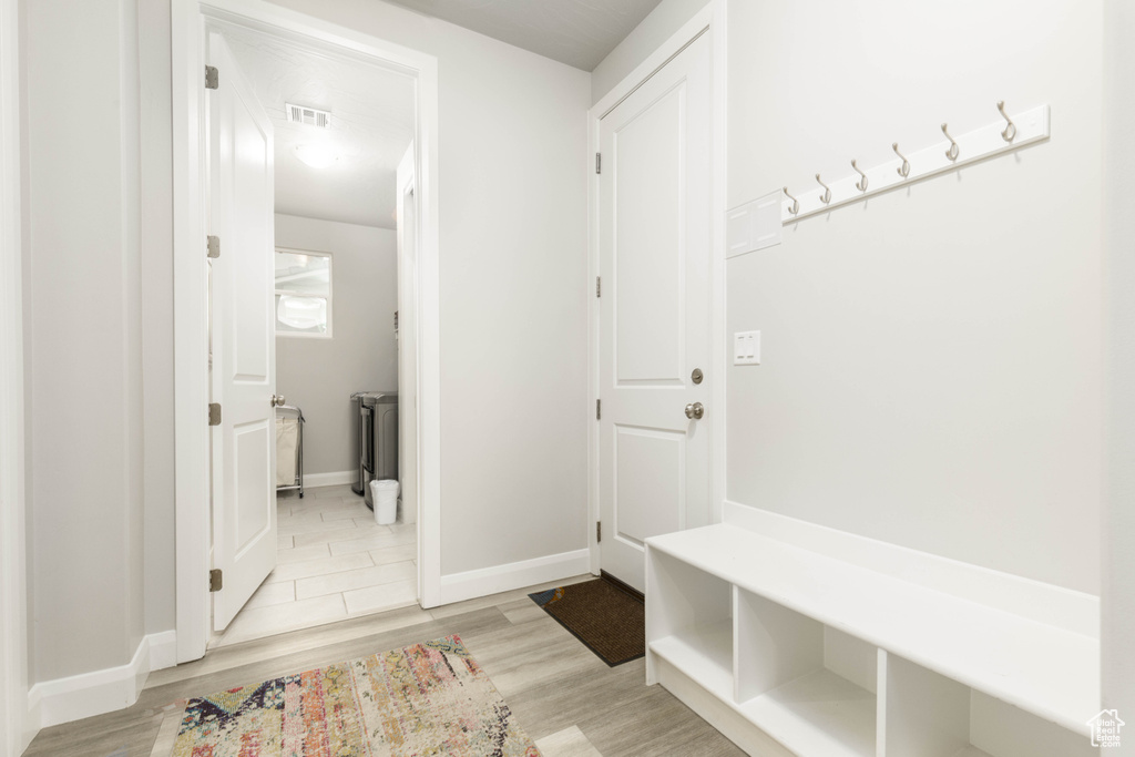 Mudroom with light wood-style floors and baseboards
