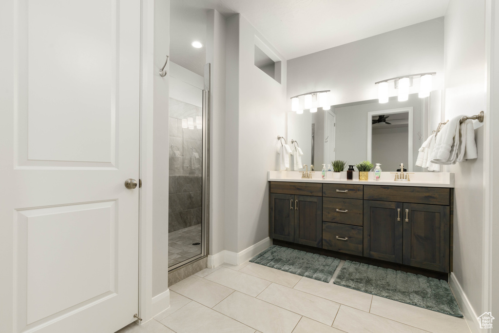Full bath featuring a stall shower, double vanity, baseboards, tile patterned floors, and ceiling fan