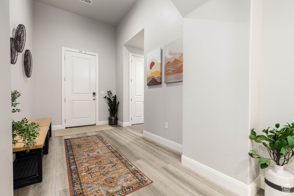 Hall with light wood-style flooring and baseboards