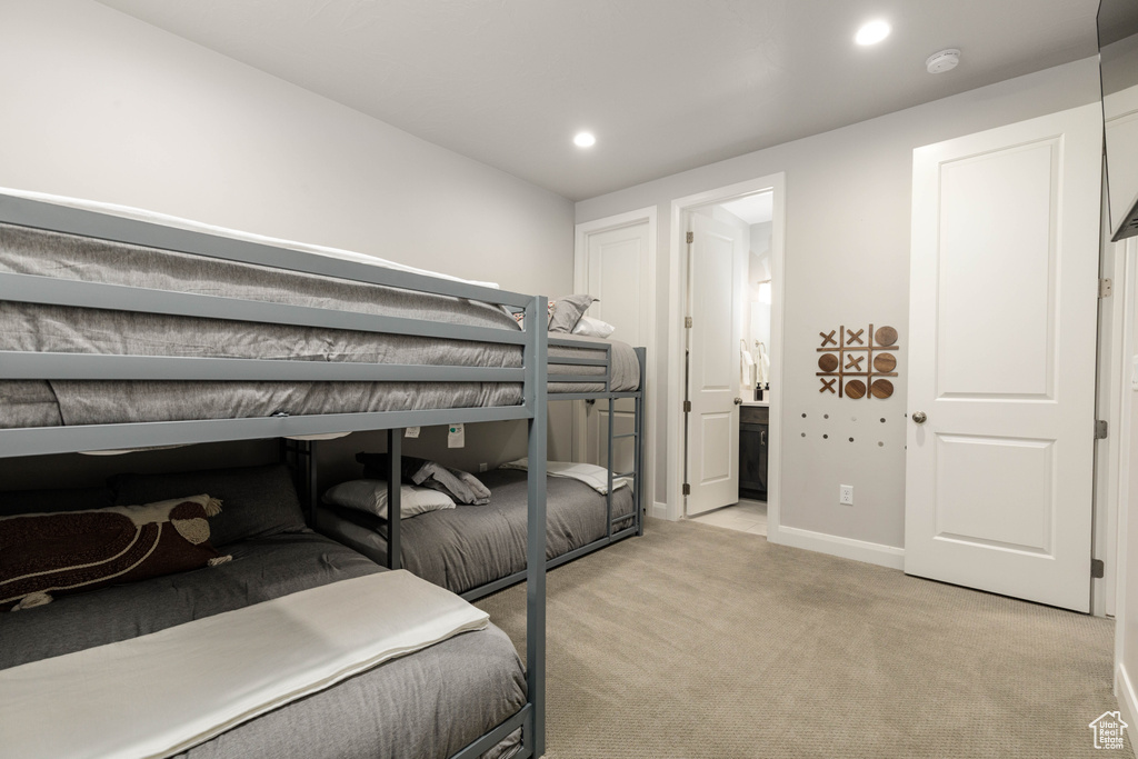 Bedroom with light colored carpet, recessed lighting, baseboards, and connected bathroom
