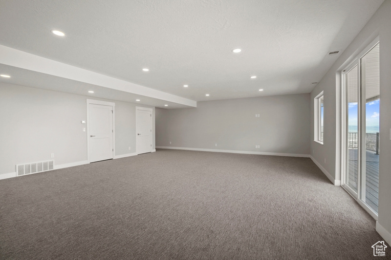 Carpeted spare room featuring visible vents, recessed lighting, and baseboards