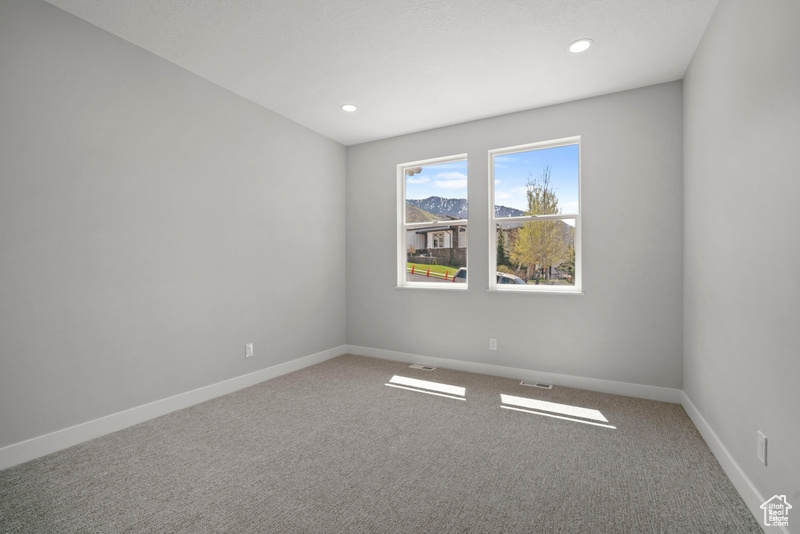 Spare room featuring visible vents, carpet flooring, and baseboards