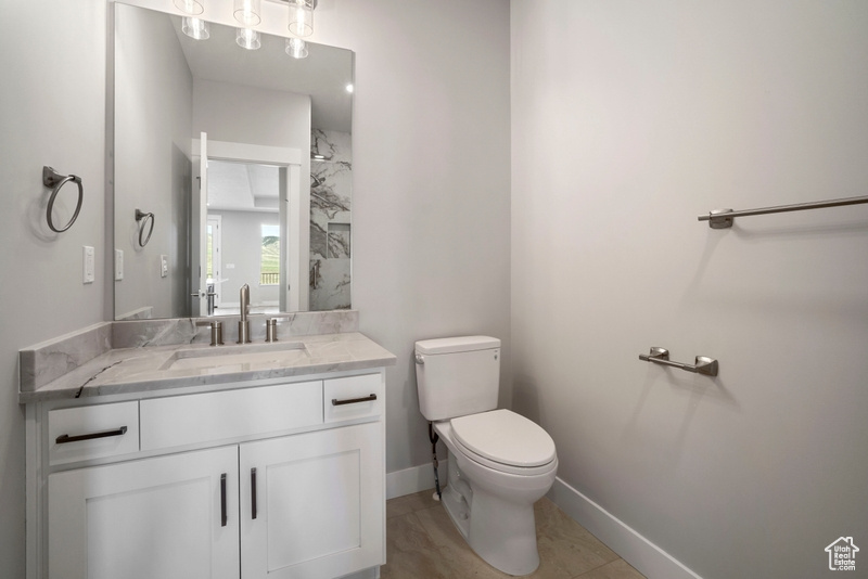 Bathroom with vanity, toilet, and baseboards