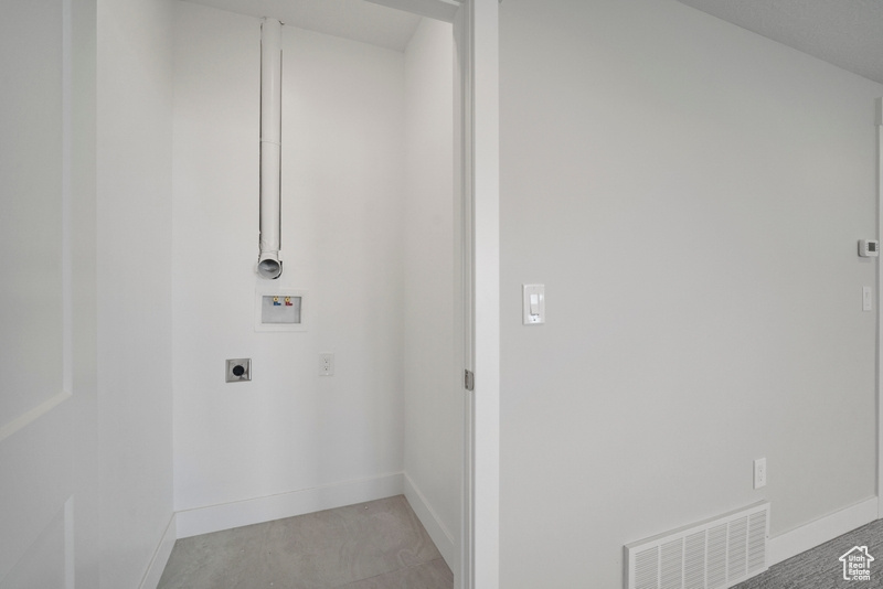 Clothes washing area featuring hookup for an electric dryer, visible vents, baseboards, hookup for a washing machine, and laundry area