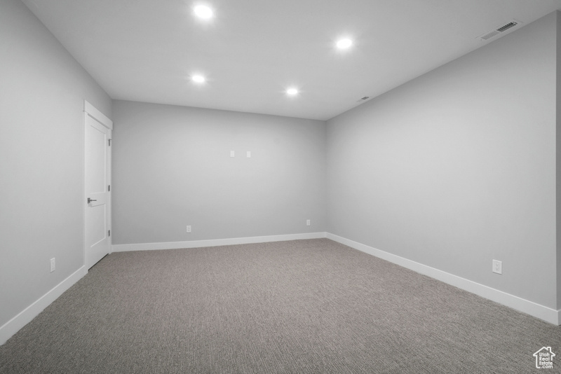 Carpeted spare room featuring recessed lighting, visible vents, and baseboards