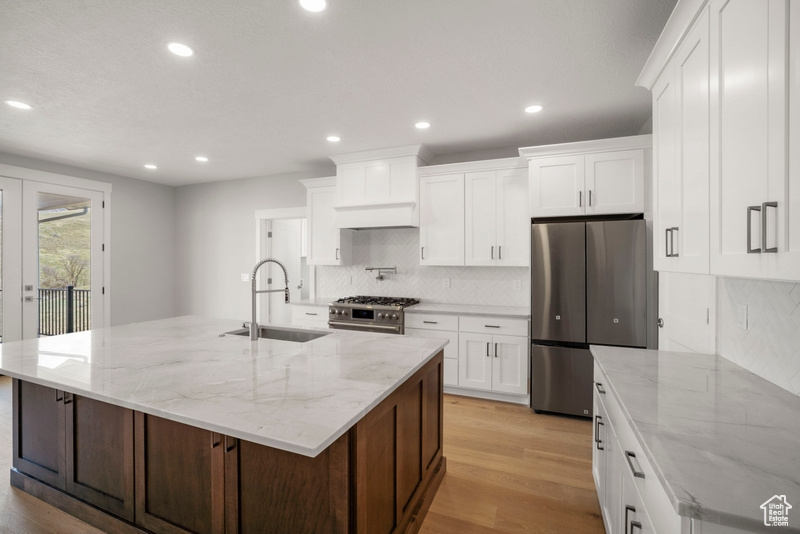 Kitchen featuring light wood finished floors, recessed lighting, a sink, and stainless steel appliances