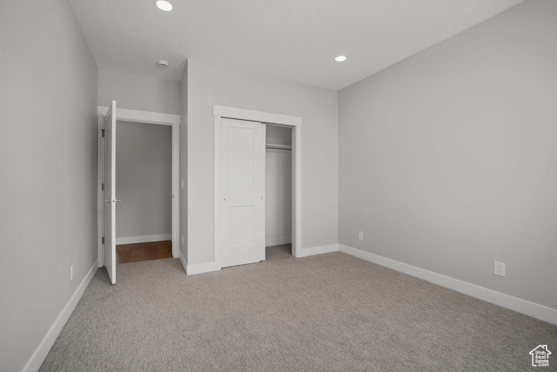 Unfurnished bedroom featuring a closet, carpet flooring, and baseboards