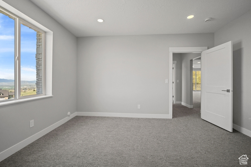 Spare room featuring recessed lighting, carpet floors, and baseboards