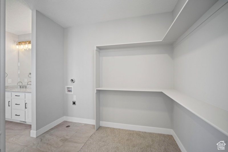 Laundry room with hookup for a washing machine, laundry area, hookup for an electric dryer, a sink, and baseboards