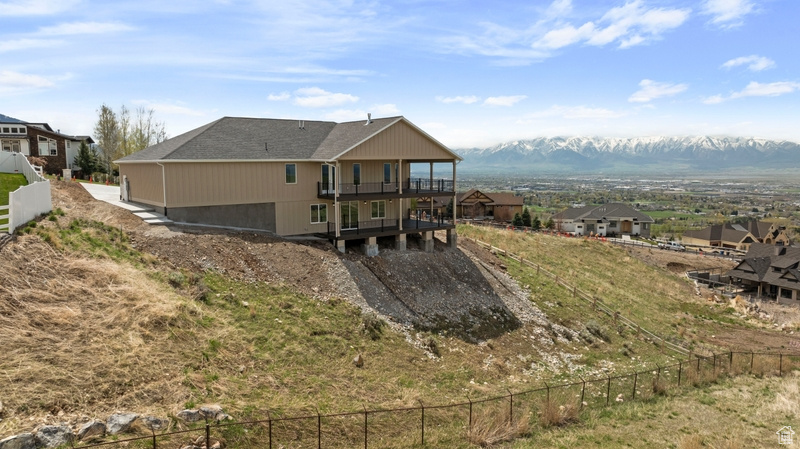 Rear view of house featuring fence and a wooden deck