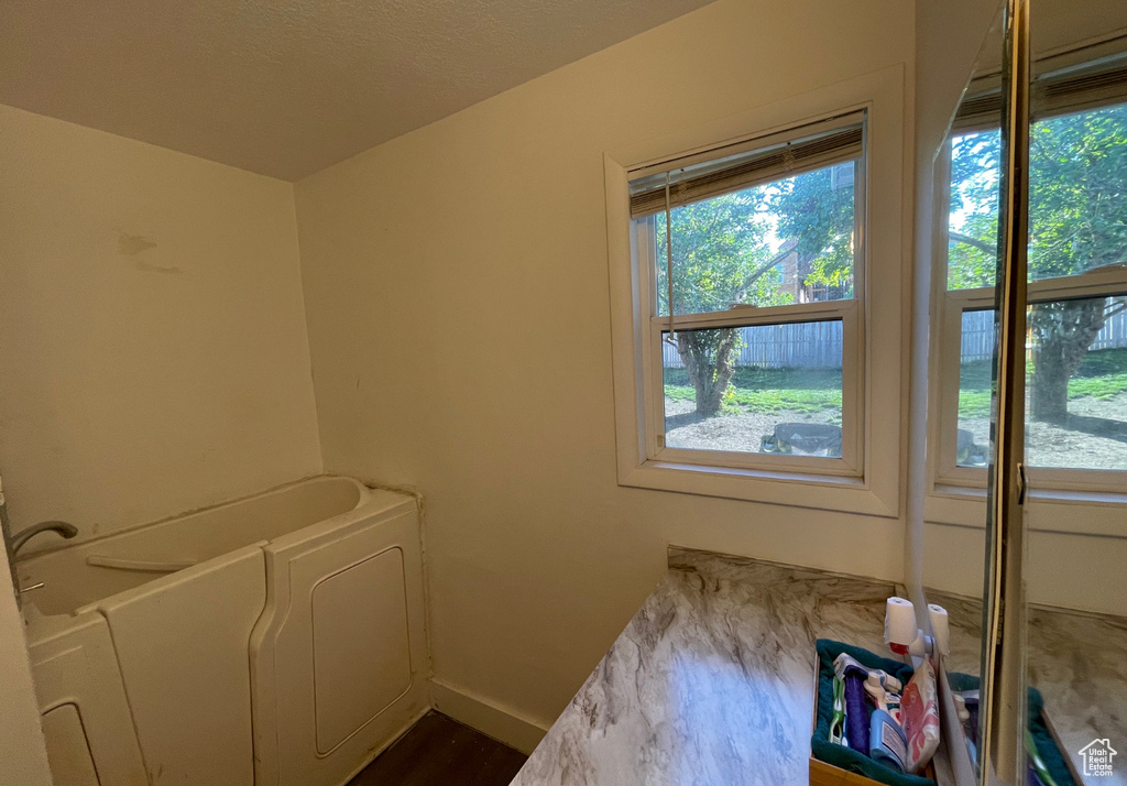 Laundry room with baseboards, a healthy amount of sunlight, and dark wood finished floors