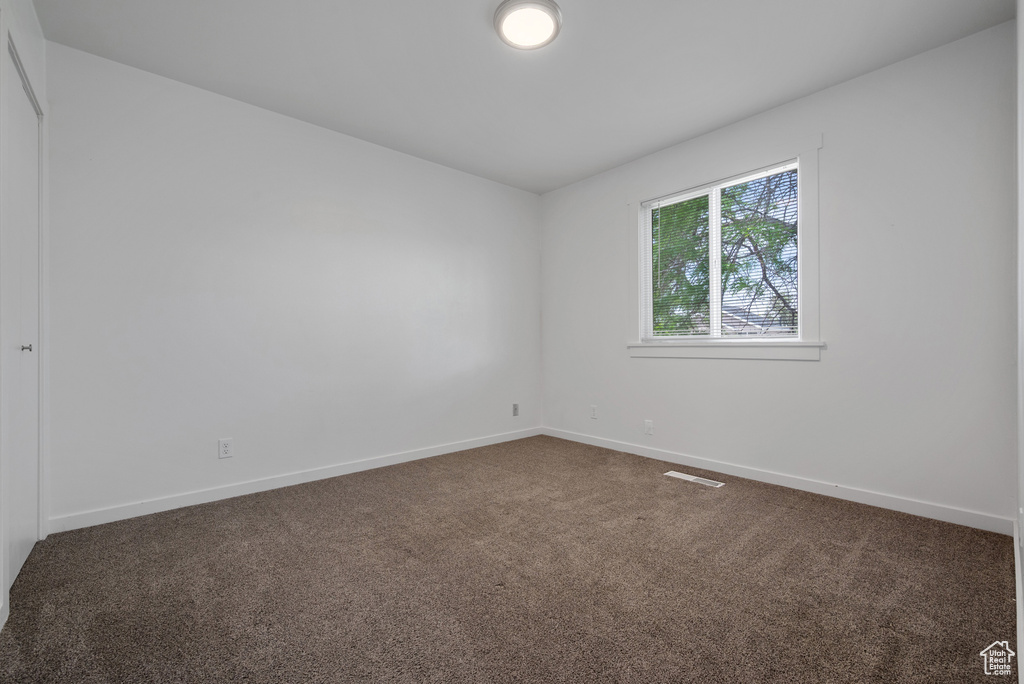 Spare room featuring carpet and baseboards