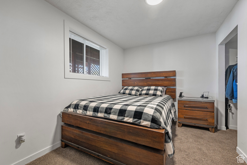 Bedroom featuring light carpet and baseboards