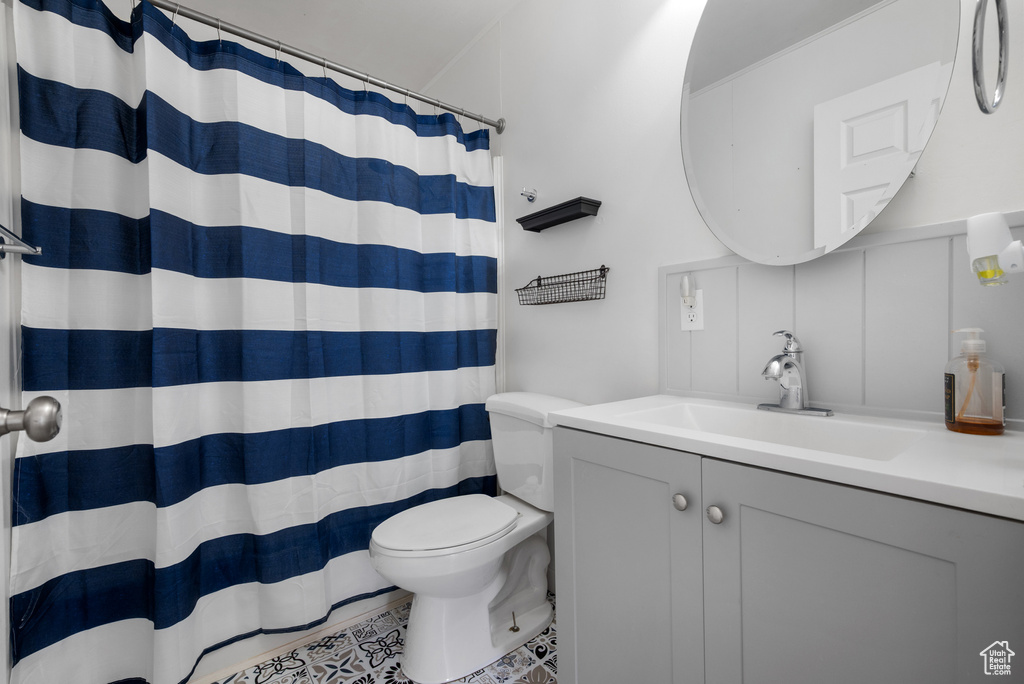 Full bathroom with toilet, vanity, and a shower with shower curtain