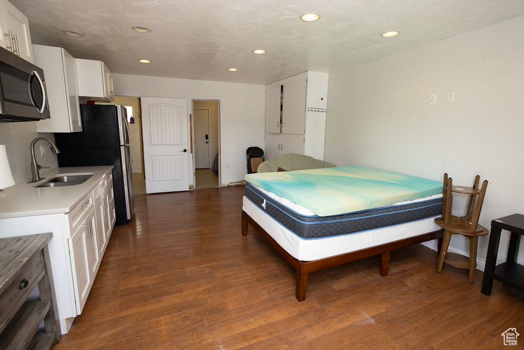 Interior space featuring recessed lighting, baseboards, dark wood-style floors, and a sink