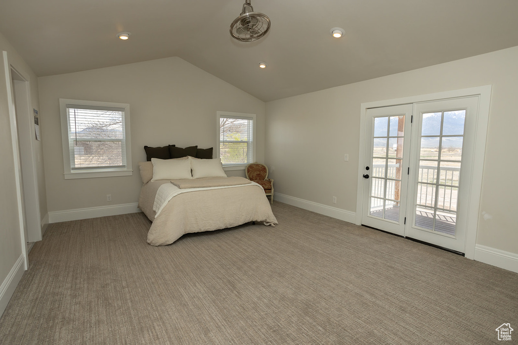 Bedroom featuring baseboards, access to outside, carpet, and vaulted ceiling