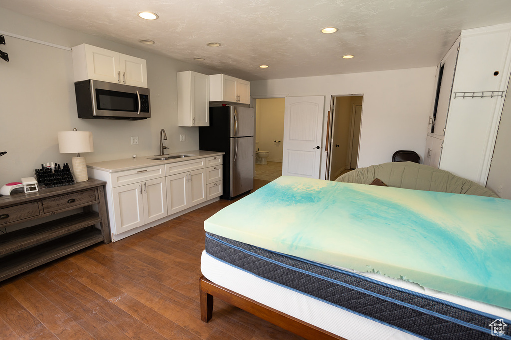 Bedroom featuring dark wood finished floors, recessed lighting, a sink, and freestanding refrigerator