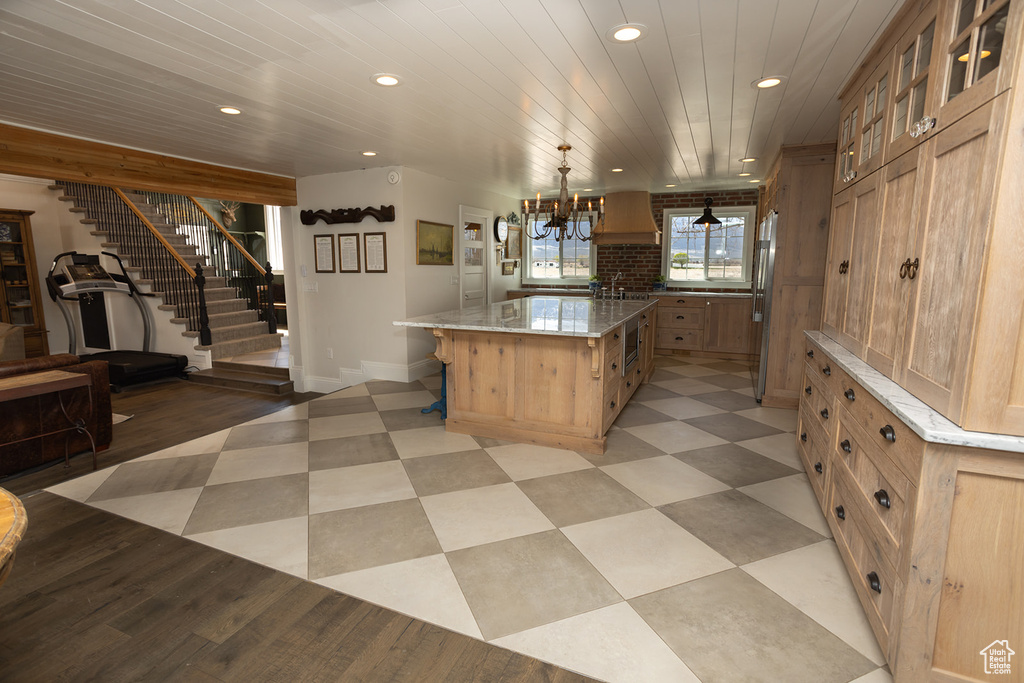 Kitchen featuring glass insert cabinets, recessed lighting, a breakfast bar area, and a large island
