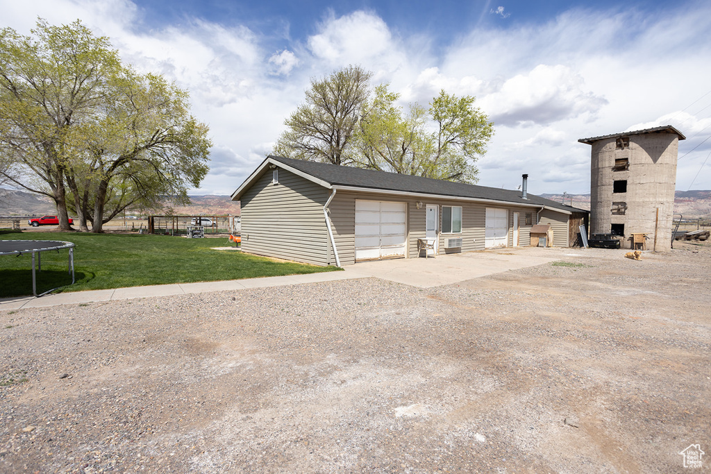 View of front of home with a front lawn and a trampoline