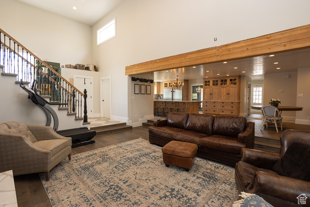Living area with baseboards, stairway, and wood finished floors