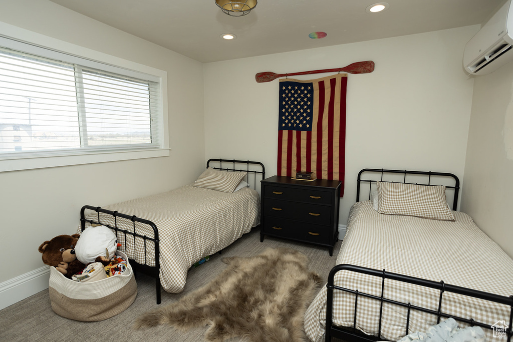 Carpeted bedroom with baseboards, recessed lighting, and an AC wall unit