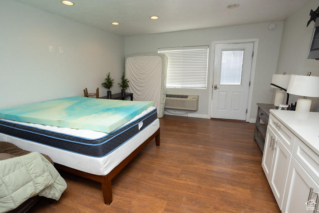 Bedroom featuring recessed lighting, dark wood-style flooring, and a wall mounted AC