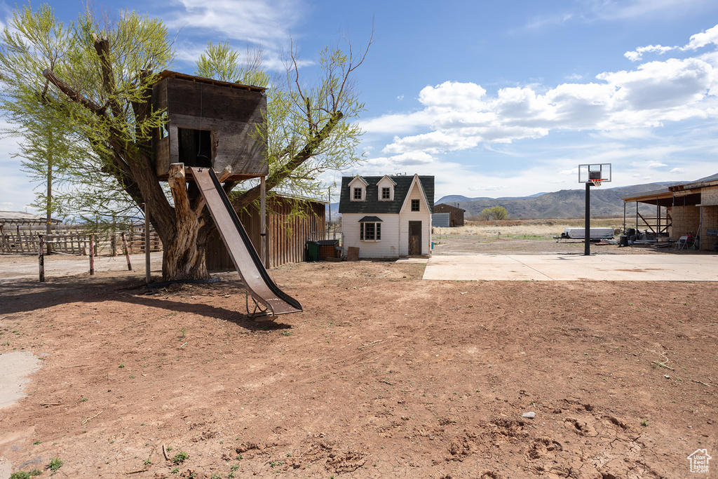 View of yard featuring a mountain view, fence, and an outdoor structure