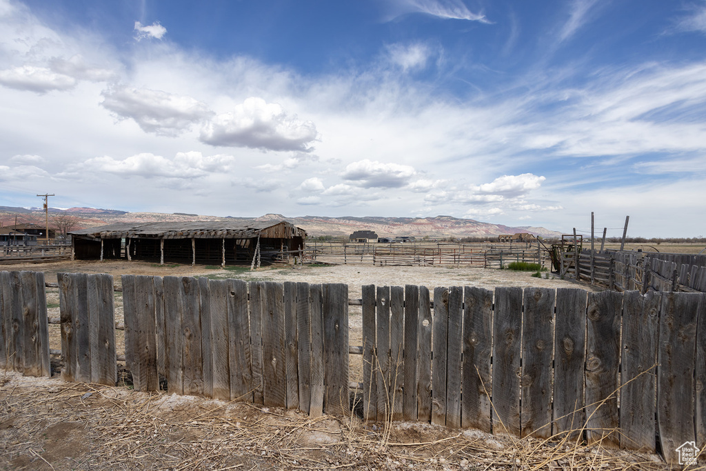 View of yard with an outdoor structure, a rural view, an exterior structure, and a mountain view