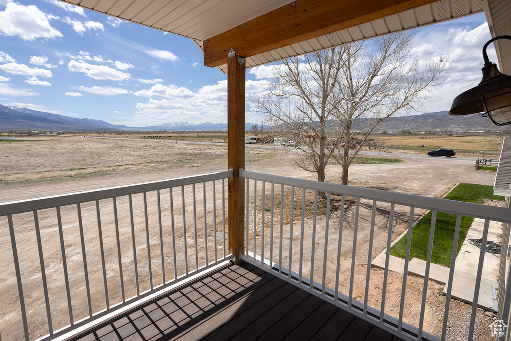 Wooden deck featuring a rural view and a mountain view