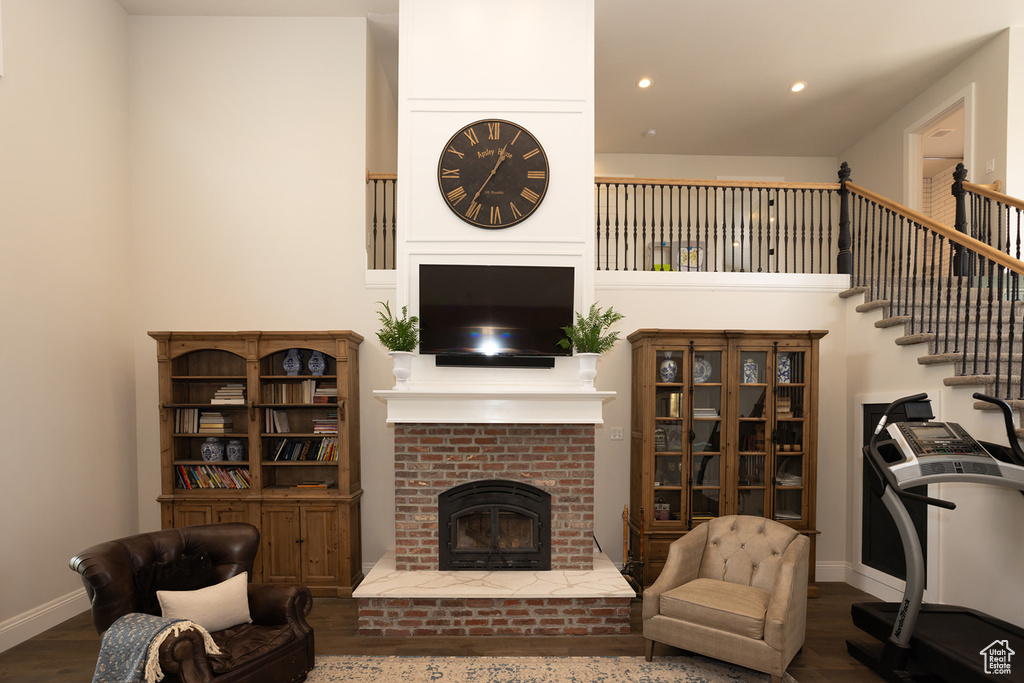 Living area with a brick fireplace, wood finished floors, recessed lighting, and baseboards