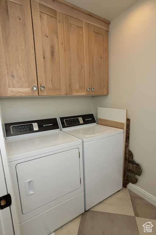 Laundry room with baseboards, cabinet space, and separate washer and dryer