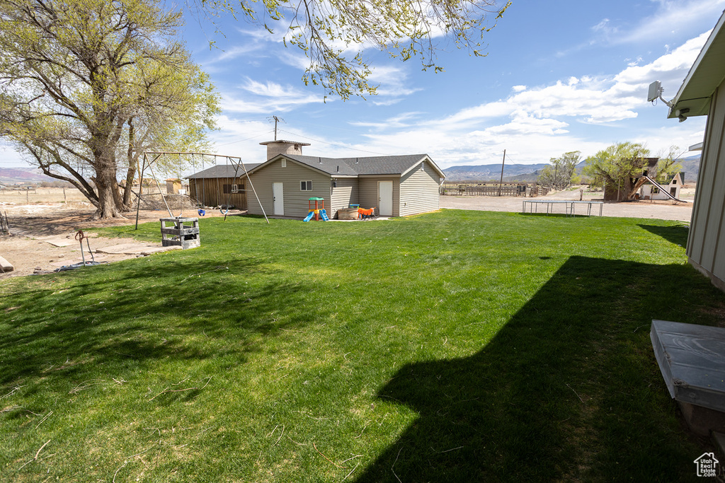 View of yard with a mountain view and fence