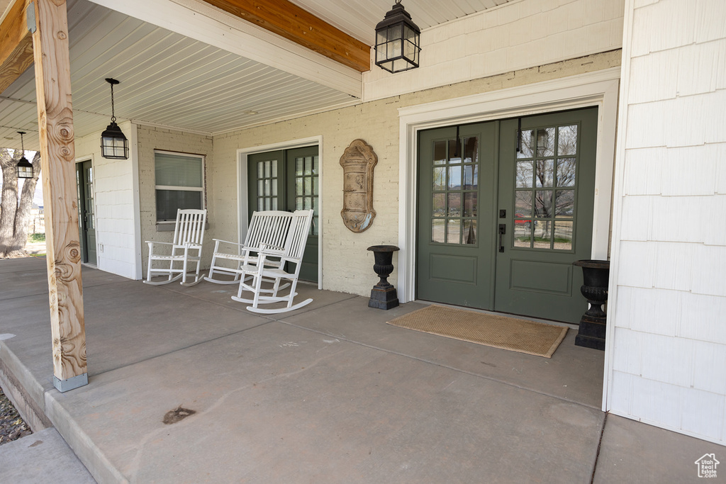 Entrance to property with covered porch and french doors