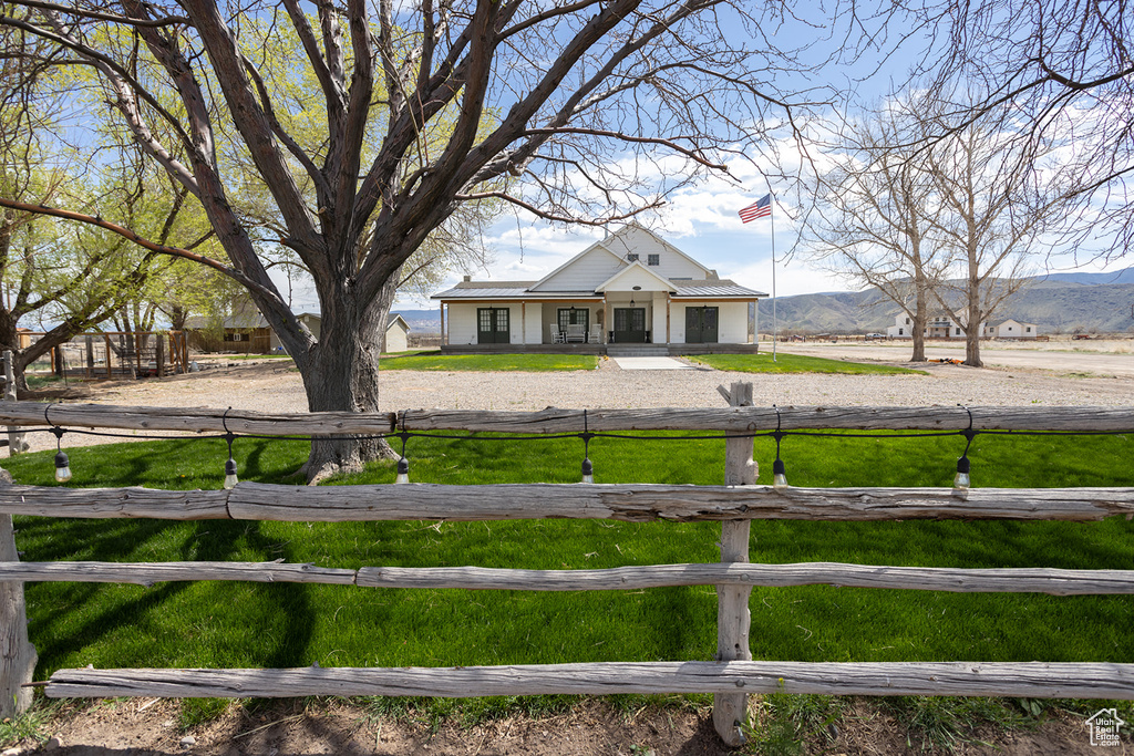 View of yard with a mountain view, covered porch, and fence