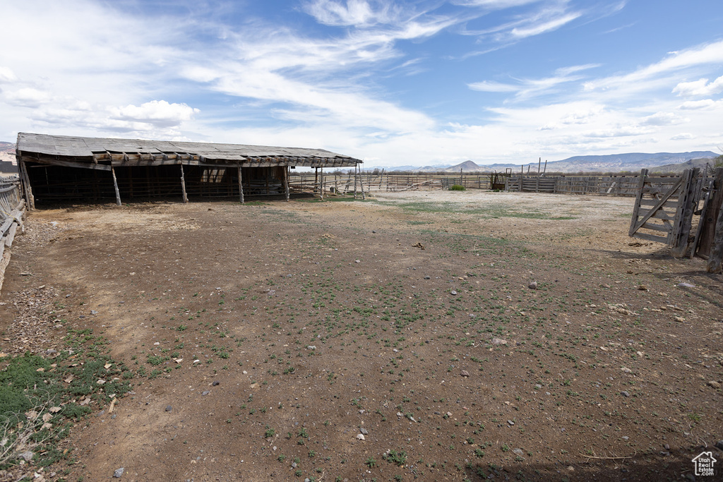 View of yard featuring a mountain view, an outdoor structure, and an exterior structure