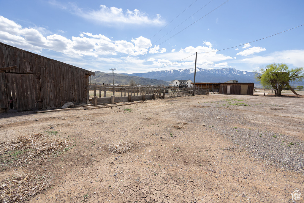 View of yard featuring a mountain view, fence, and an outbuilding