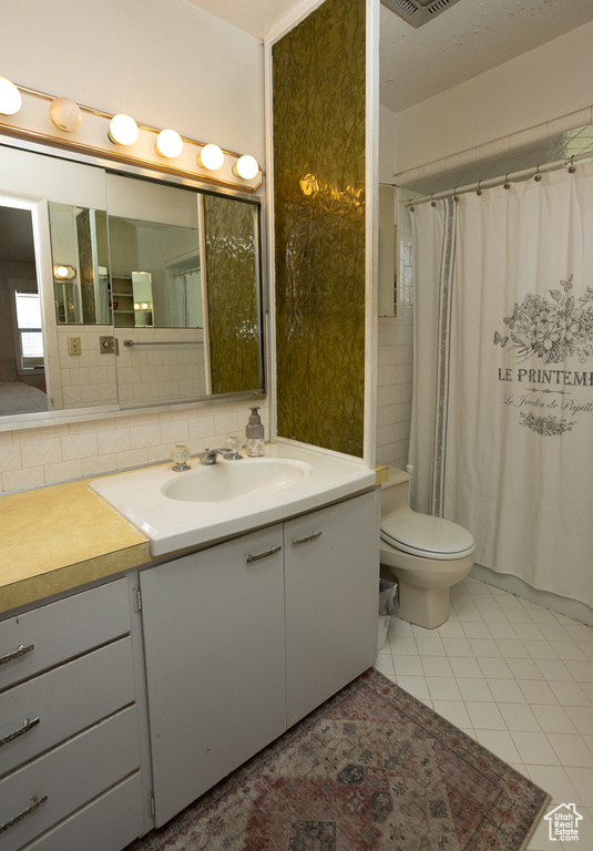 Full bathroom with visible vents, a shower with shower curtain, toilet, tile patterned floors, and vanity