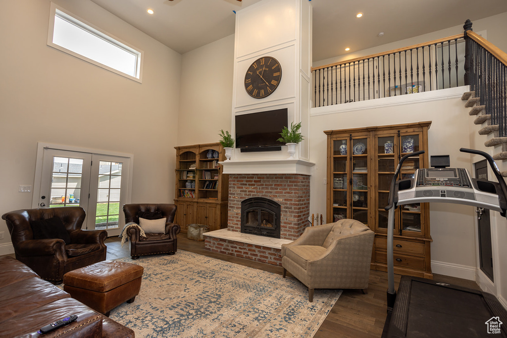 Living area featuring wood finished floors, plenty of natural light, and a high ceiling